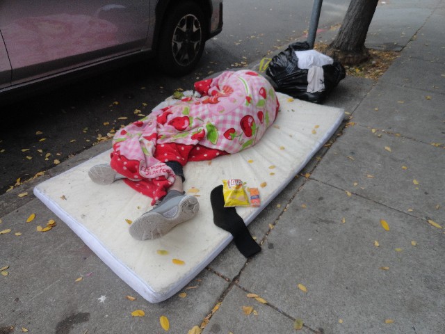 Homeless person sleeps with chips and crackers from the little way homeless outreach charity